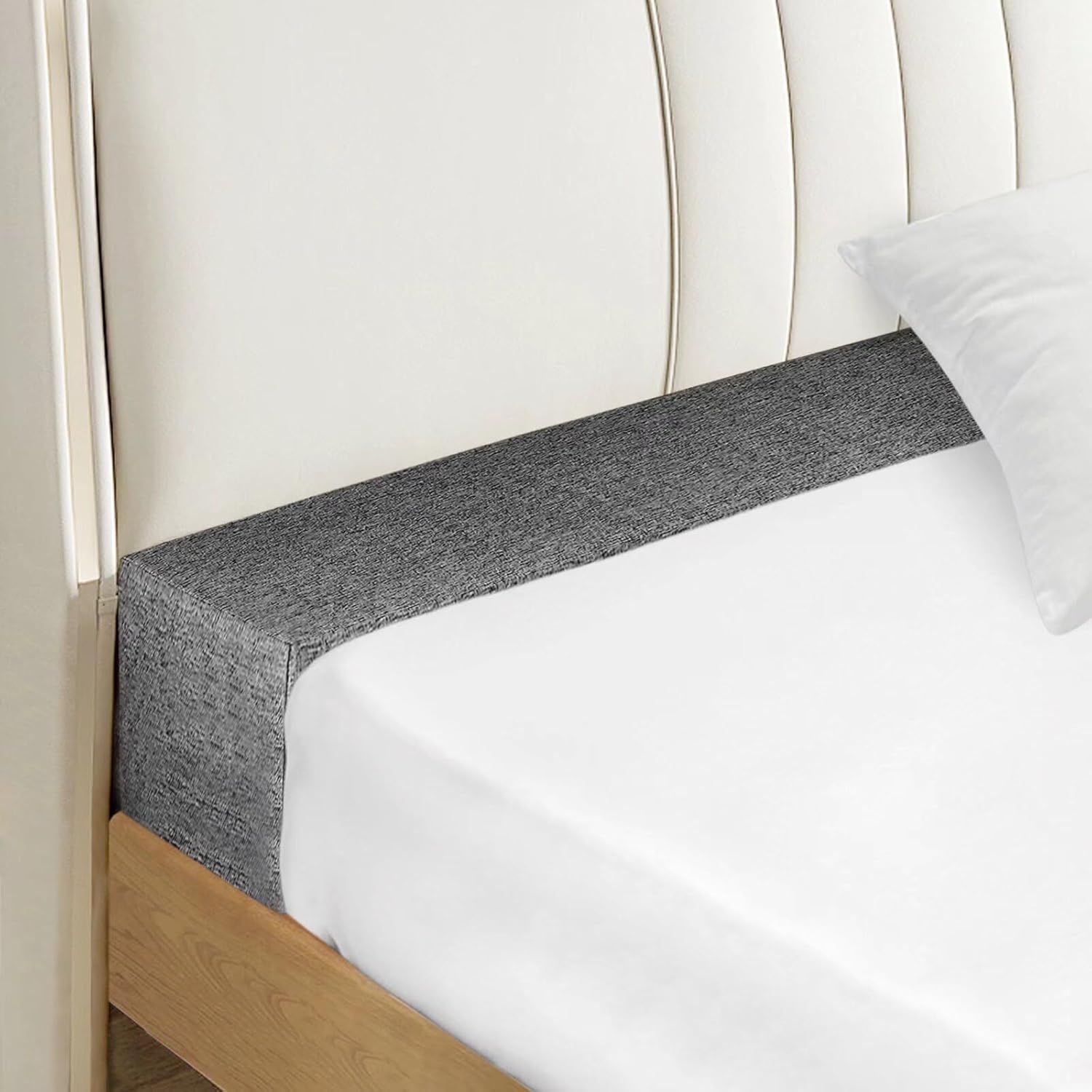 Dark gray bed gap filler wedge along the mattress edge