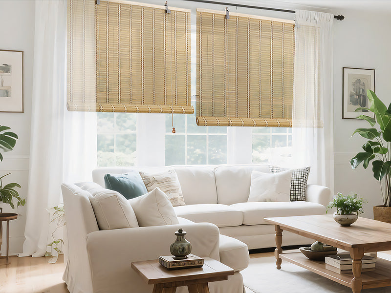 Light tan bamboo roll-up window shade with multiple slats and cord pulls on rod.