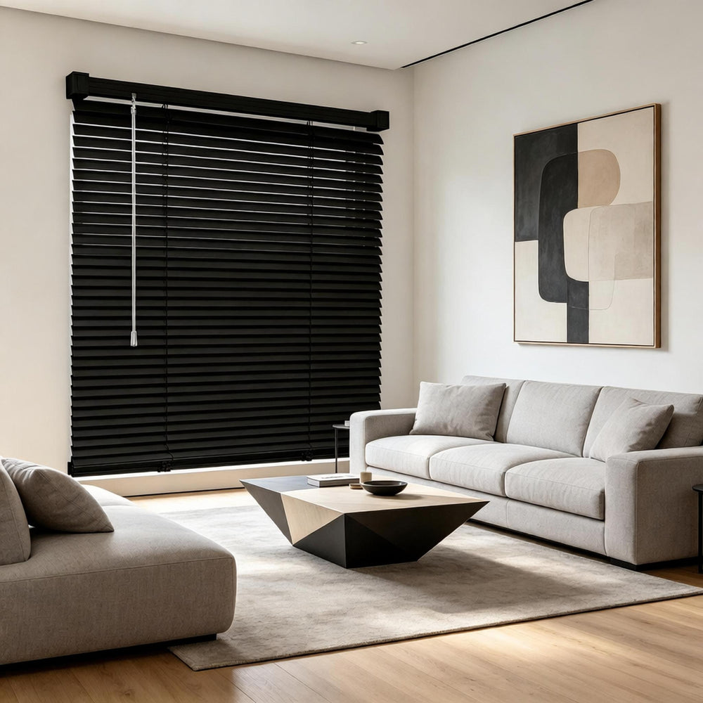 Black cordless vinyl mini blinds covering a large window in a living room setting
